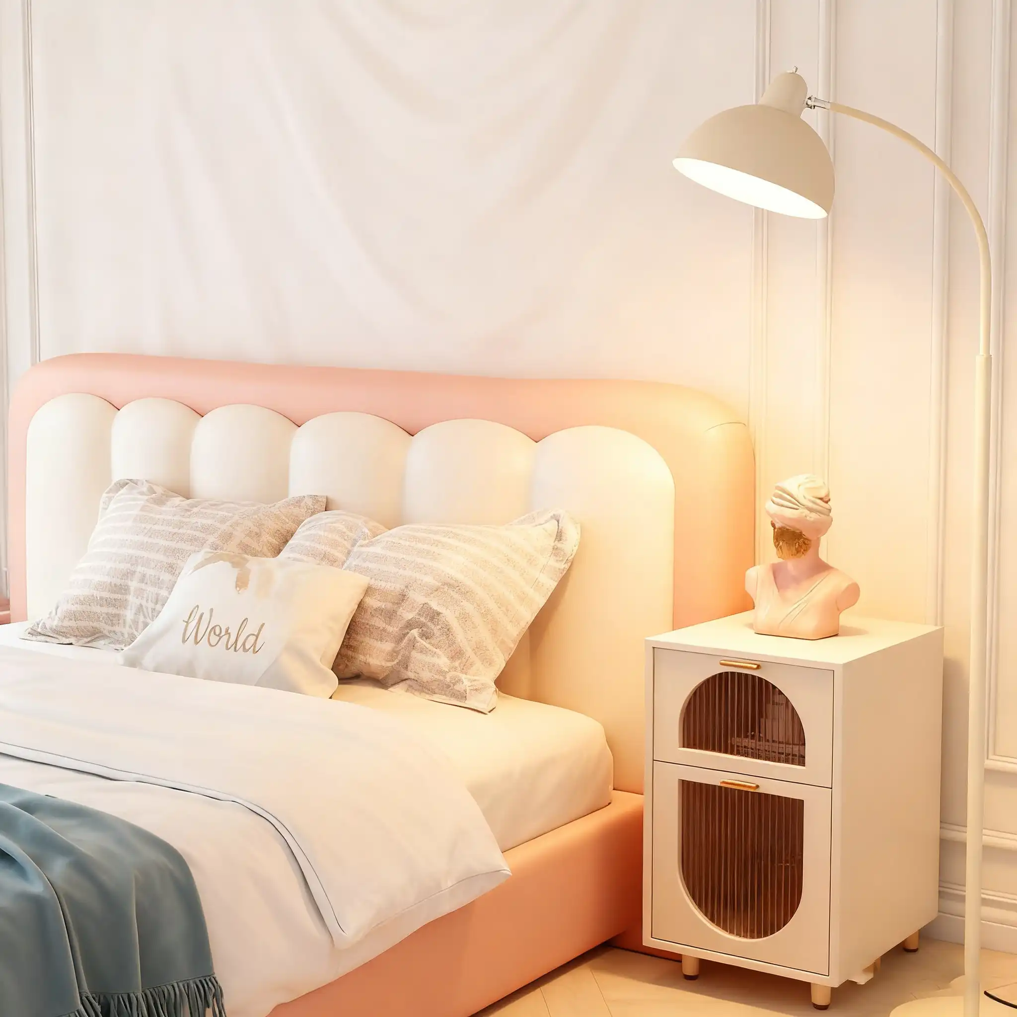 A cozy bedroom with a pink and white tufted headboard, decorative pillows, a white nightstand with a bust sculpture, and a beige arc floor lamp.